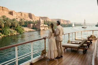 Couple élégant sur le pont d'un bateau de croisière cinq étoiles naviguant sur le Nil face aux temples égyptiens